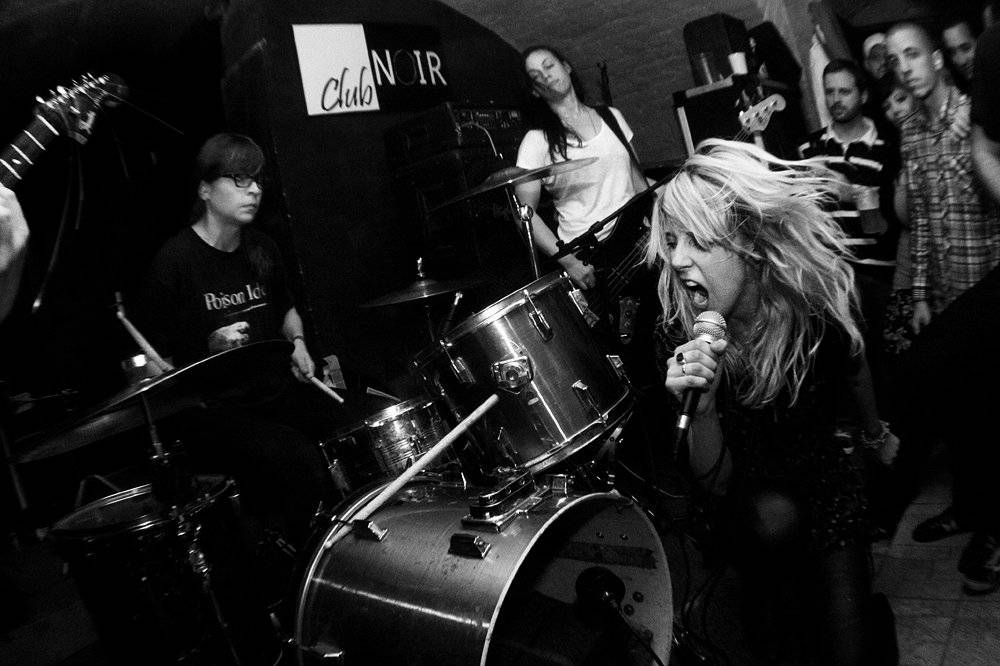 A black and white photo of a group of people playing drums.